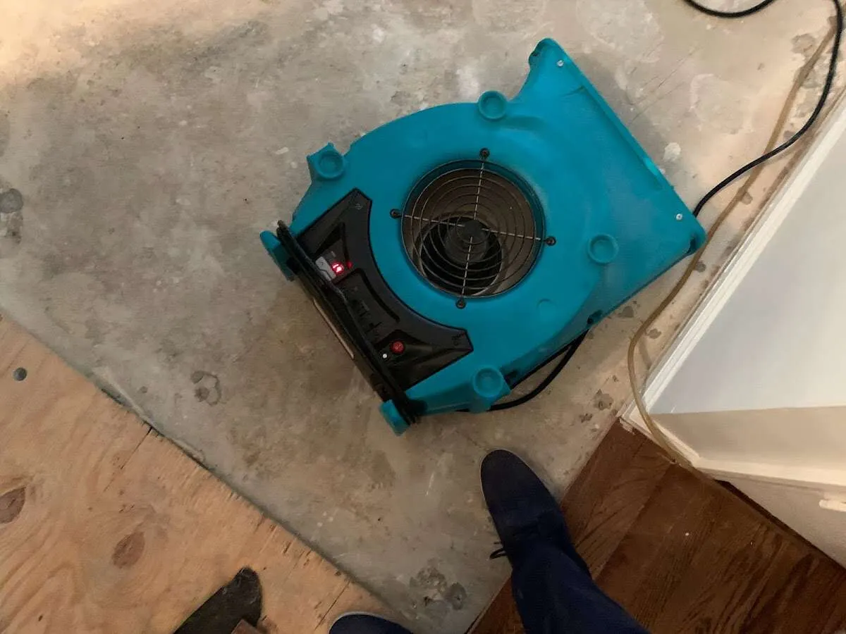 Air mover drying subfloor during Leak Detection & Repair in St. Johnsbury